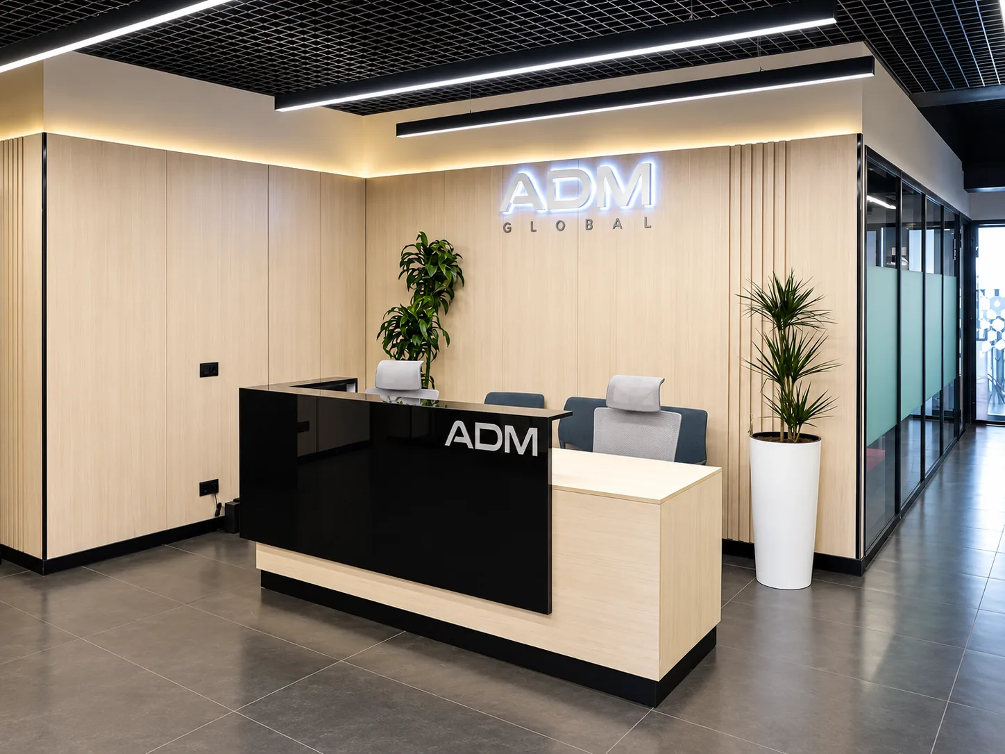 Ресепшн ADM Global со стойкой и стеновыми панелями под светлое дерево